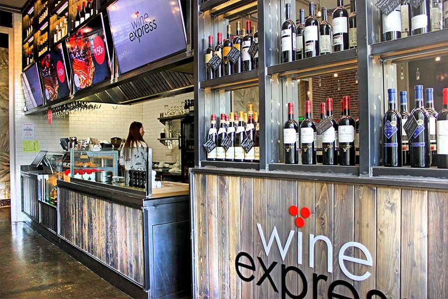 Барные стойки и высокие стулья в интерьере винотеки Wine Express
